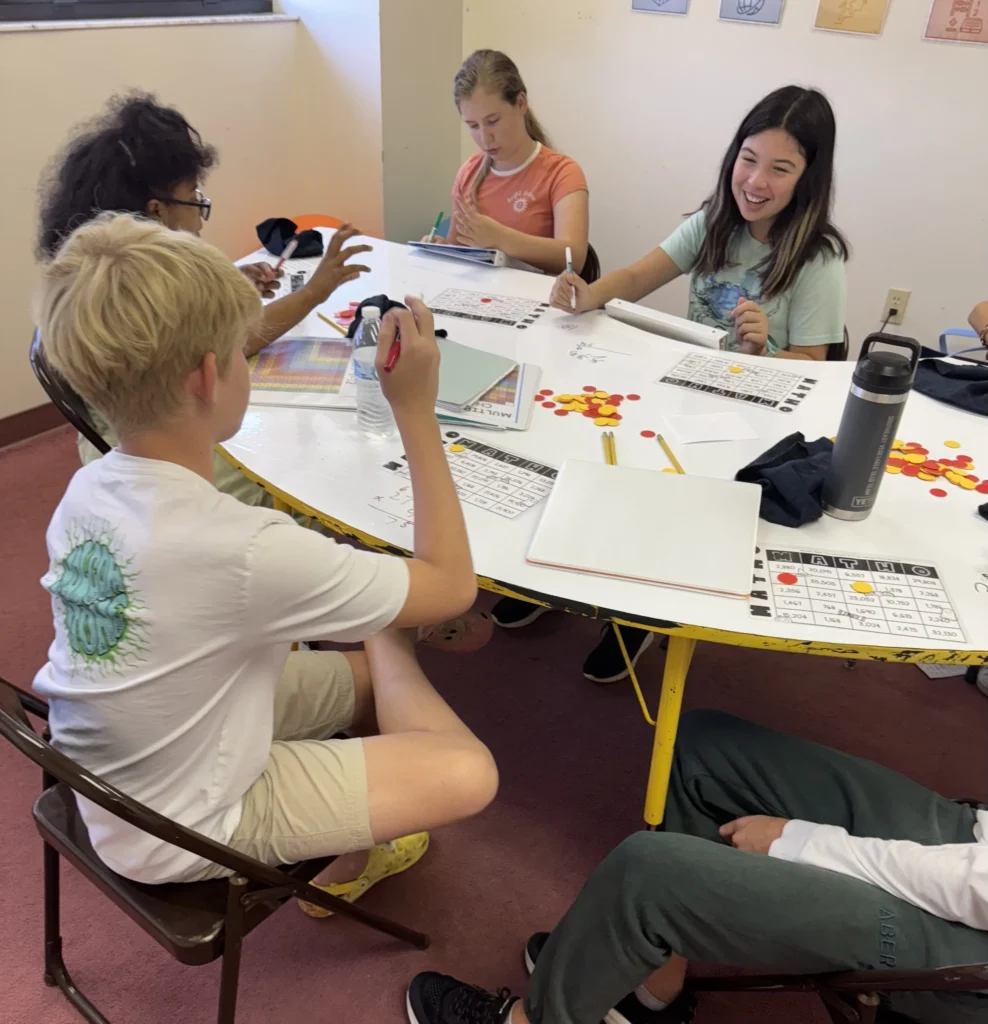 Students laughing while playing a MATH-O game in a small group class